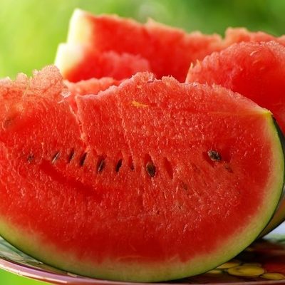 Watermelon is a large fruit that grows on the ground and is usually an oval shape.