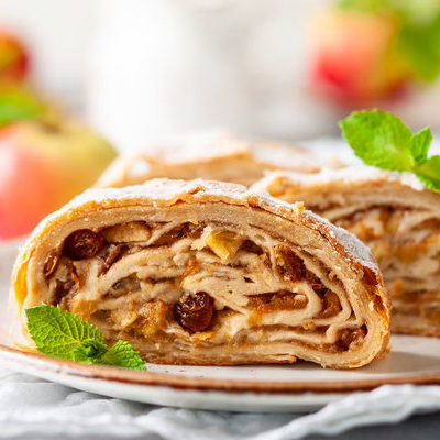 Apple strudel (or Apfelstrudel) is an Austrian dessert made of layered pastry with a grated apple filling inside.