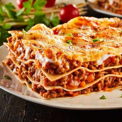 Lasagna is a prepared dish of Italian origin that includes stacked layers of pasta, tomato and bechamel sauces, meat, vegetables, and cheese.