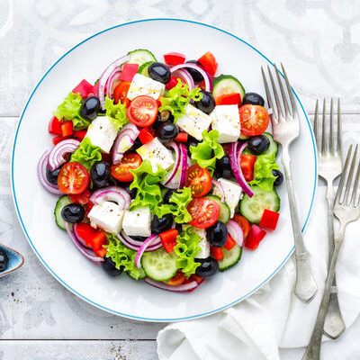 A Greek salad is a salad which consists of tomatoes, cucumbers, onions, olives, and feta cheese, although it can contain seasonings and herbs, as well.