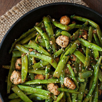 Green beans are a long, thin vegetable that grows on plants or vines.