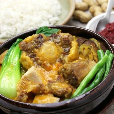Kare-kare is a Filipino dish made with oxtail, beef cuts, tripe, and pock hocks as the base of a stew. Vegetables such as banana flower, long beans, okra, and eggplant are also added.