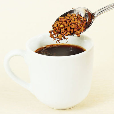 Instant coffee is a beverage produced from roasting, grinding, and brewing coffee beans.