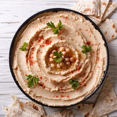 Hummus is a spread made from chickpeas, olive oil, lemon juice, garlic, sesame seed paste (tahini), and other ingredients.