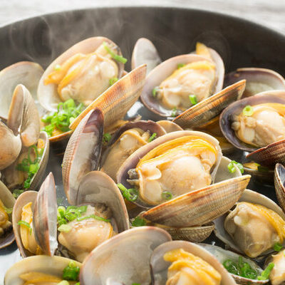 The clam falls under the category of seafood. It is a type of edible mollusk that lives on river beds and the ocean floor, unlike scallops which only live in saltwater.