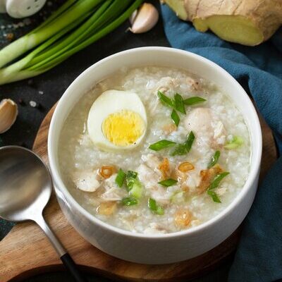 Arroz caldo is a Filipino dish made with rice, chicken, herbs, and spices, such as ginger. It is a type of thick soup served with a boiled egg and fish sauce, and garnished with garlic, scallions, and black pepper.